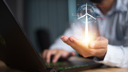 Close up of businessman hand pointing at cellphone with glowing digital wind mill turbine hologram....