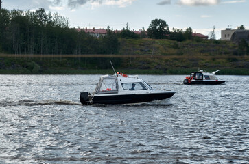 Fototapeta na wymiar Dark speedboat goes on the water
