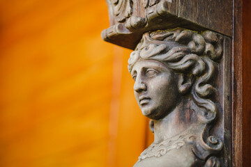 Close-up Decorative female statue in the house area with an orange background.