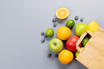 Shopping paper bag full of healthy food on grey