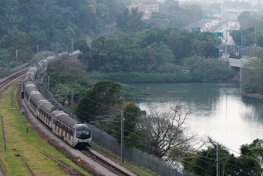 Hong Kong MTR MLR train passing a lake. 