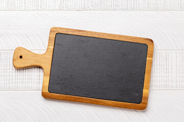Obraz na płótnie Canvas Wooden cutting board on white kitchen table
