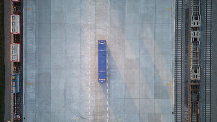 Aerial top down view of single container on cargo train terminal. Cargo train with freight train...