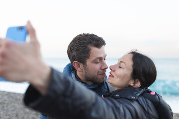 A man and a woman kiss on the beach