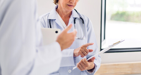 Group of professional medical doctor team work with stethoscope in uniform working discussing and talk together walking in hospital.health insurance medical care concept