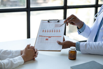 A young Asian professional doctor explains and discusses the details. Health trends from charts and graphs with patients in hospitals, ready to provide advice on health care, PM 2.5 pollution.