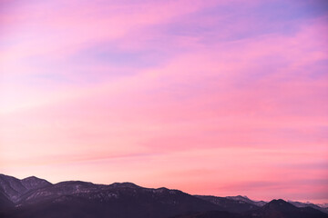 Gentle sky gradient from the setting sun over the dark silhouette of the mountains. Feeling of...