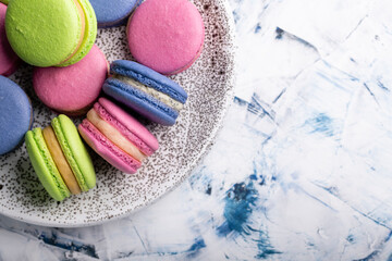 Plate with multi-colored macaroons close-up view from above