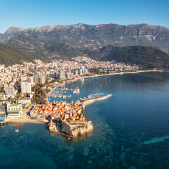 Amazing panoramic view with the city of Budva in Montenegro, old town, houses with red roofs and marina with boats..