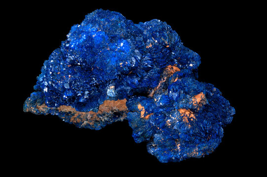 Azurite is a soft, deep blue copper mineral produced by weathering of copper ore deposits. Isolated in black background.