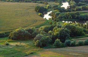 Sunny summer landscape with river.Green hills and meadows