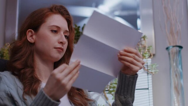 (Camera: ARRI ALEXA, real time) A young caucasian woman opens a letter and receives great news with a stack of cash. For more variations of this clip, check out this seller's other videos.