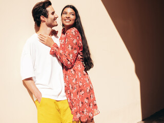 Smiling beautiful woman and her handsome boyfriend. Happy cheerful family. Sexy couple posing in the street at sunrise. During romantic date at sunny summer day outdoors. Looking at each other