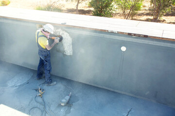 Concrete ceiling surface of the pool grinding by angle grinder