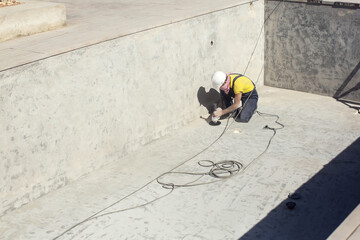 Concrete ceiling surface of the pool grinding by angle grinder