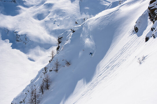 Person backcountry skiing down snowy mountain slope in Swiss Alps, Simplon Pass, Valais Canton, Switzerland
