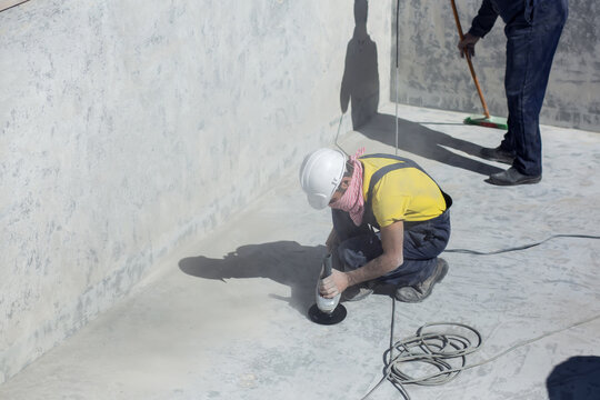 Concrete ceiling surface of the pool grinding by angle grinder