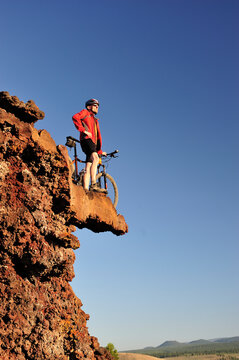 Man out on a ledge with a bike