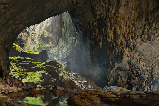 A cave explorer stands at the opening of the first doline, or skylight, in Hang Son Doong. - Powered by Adobe