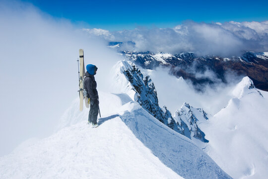 Skier standing on mountain peak, South Island, New Zealand