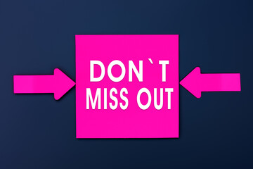 Don't miss out - inscription of a magenta paper notes and two colorful arrows over a dark blue...
