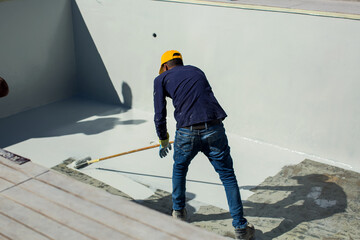 Applying epoxy paint on a surface of a pool