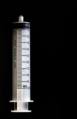 A large volume syringe on a black background