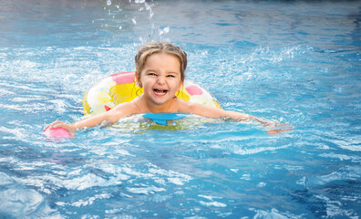 Fototapeta na wymiar Child swims in the pool