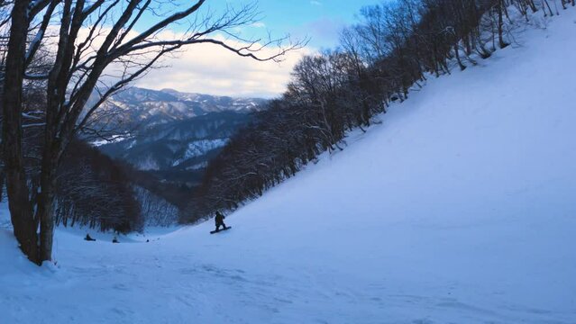 Snowboarding going down hill through the mountains of Hida, Gifu Japan