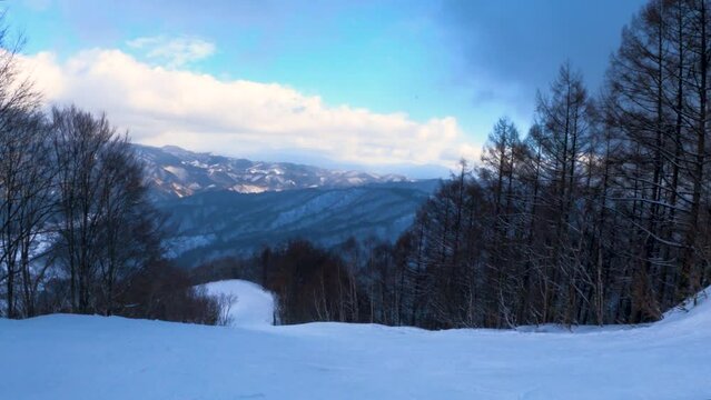 Going down hill on ski slope, first person view with Hida Mountains in Background, Japan