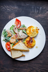 Breakfast. Salad, scrambled eggs and a sandwich