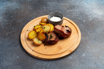 Fried meat and new potatoes on the board.