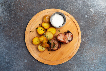 Fried meat and new potatoes on the board.