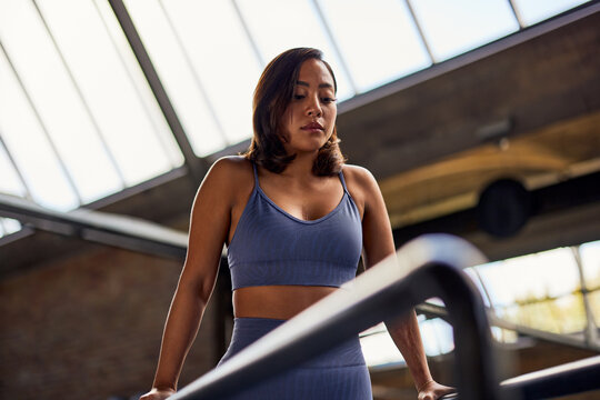 Fit woman exercising on parallel bars at the gym