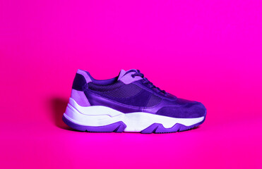Trendy woman sneakers shoes, trend duotone neon ultraviolet color lightning. Colored light pink, magenta, creative trendy effect.