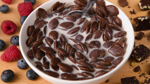 Stirring a bowl of freshly made chocolate cereal.