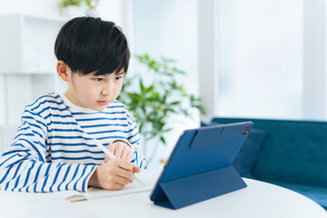タブレットを見ながら勉強する男の子