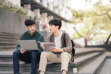 Asian students joining study book, smiling with laptop computer tablet at high school university, college, vacation, summer vacation.