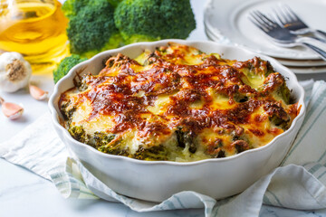 Casserole Cauliflower and broccoli baked with cheese sauce in a pot close-up on a wooden table....