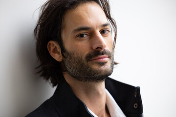 Obraz premium portrait d'un homme souriant, brun au cheveux longs, 30 ans avec un beau visage. Fond blanc