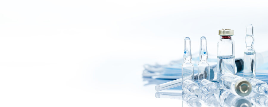 Medical vials for injection with a syringe and ampules on a light background