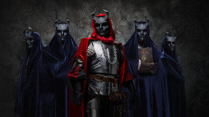 Studio shot of esoteric brotherhood of five people with robes and horned masks.