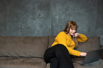 Young girl or woman with a cool attitude freelancer working from home for a foreign modern company...