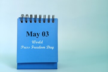 May 3 as World Press Freedom Day date reminder on blue desk calendar. Celebration concept.	