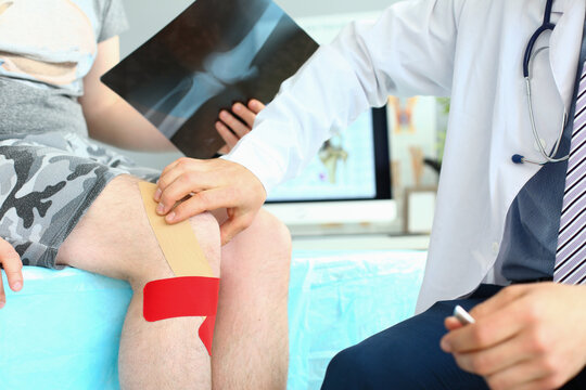 X-ray image of knee injury patient with kinesio tape on knee at orthopedist appointment