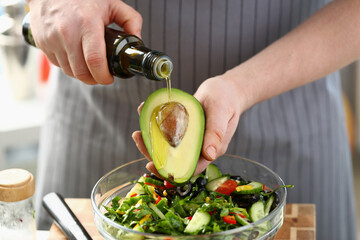 Chef prepares a salad of fresh green vegetables and avocado with butter