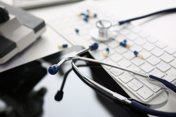 Medical pills or vitamins with keyboard and stethoscope