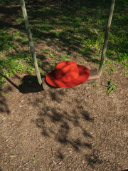 red hat on a swing in the park
