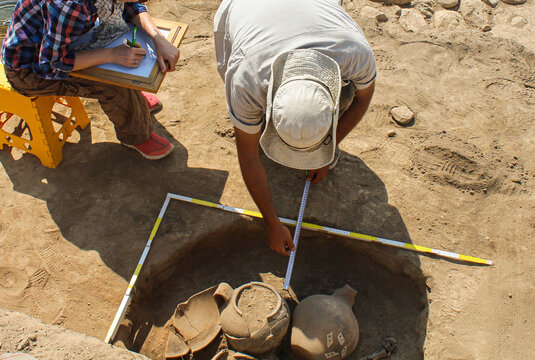 Archaeologists Documenting Pottery &ndash; Field Sketching at an Excavation