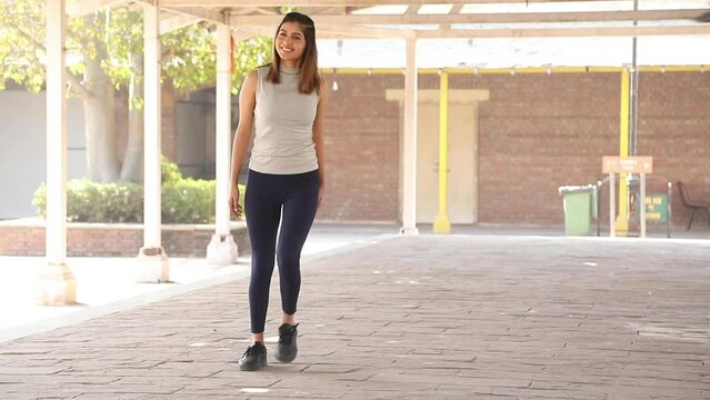 Stock video footage of an Indian fit woman performing walking cardio exercise.
